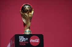 the world cup trophy is displayed in front of a red background