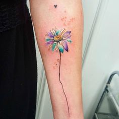 a woman's arm with a flower tattoo on the left side of her leg