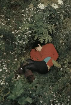 a woman is sitting in the middle of flowers