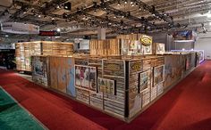 a large display area with wooden boxes on the floor and red carpeted floors in front of it