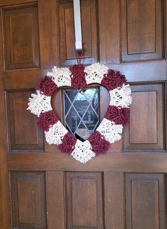 a heart shaped wreath hangs on the front door