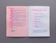 an open book with pink lettering on it