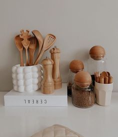 wooden utensils and spoons are sitting on top of a white countertop