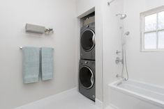 a washer and dryer in a white bathroom