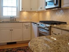 a kitchen with white cabinets and granite counter tops