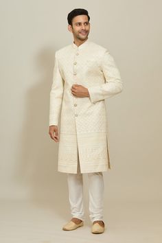 Cream sherwani featuring thread and sequin work all over. Paired with a white churidar. - Aza Fashions Formal Off White Kurta With Cutdana, White Churidar With Cutdana For Ceremonial Occasions, Festive White Churidar With Naqshi Detailing, Ceremonial White Churidar With Cutdana Details, Off White Bandhgala With Pallu For Eid, Ceremonial White Churidar With Cutdana, Festive Off White Bandhgala With Pallu, White Bollywood Bandhgala For Festive Occasions, Formal Off-white Kurta With Cutdana