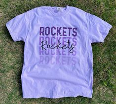 Get this popular new Rockets stacked text shirt and show off your school spirit in style!  Each shirt is printed in-house by me using high-quality materials on a Comfort Colors shirt, known for its exceptional comfort, style, and durability. Available in unisex sizes S to 3X, and youth sizes, we've got you covered regardless of your preferred fit. This Cardinals stacked text Shirt features a classic crew neck and short sleeves, making it suitable for year-round wear. The flattering silhouette en Purple College T-shirt With Team Name, Spring Varsity T-shirt With Graphic Print, School Spirit T-shirt For Game Day In Spring, School Spirit Letter Print Tops For College Events, Sporty Shirt With Text Print For Spring, Spring Sporty Shirt With Text Print, Sporty Spring Shirt With Text Print, School Spirit Shirt With Screen Print For Game Day, School Spirit T-shirt With Letter Print For College Events