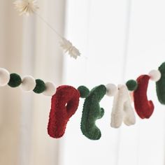 there is a christmas decoration hanging from the string with stockings on it and snowflakes in the background