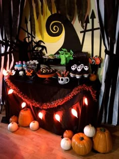 a table topped with lots of cupcakes and halloween decorations