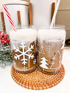 two glasses filled with liquid sitting on top of a wooden tray next to christmas decorations