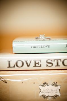 a stack of books with wedding rings sitting on top of each other in front of the first love logo