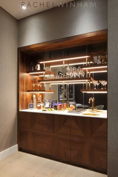 a kitchen with wooden cabinets and shelves filled with wine glasses