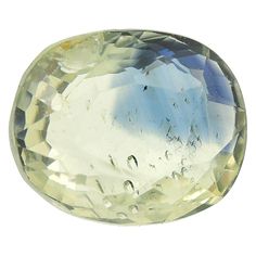 an oval shaped yellow topazte stone on a white background with water droplets in the foreground