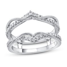 a white gold wedding ring set with diamonds on the sides and an intricate design in the middle