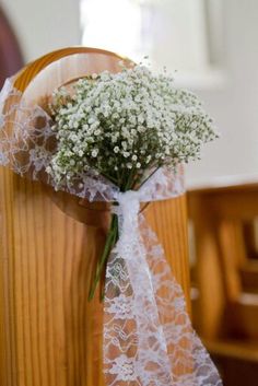 a bouquet of baby's breath sitting on top of a church pew