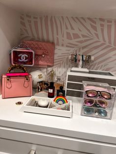 a white counter topped with lots of different types of purses and sunglasses on top of it