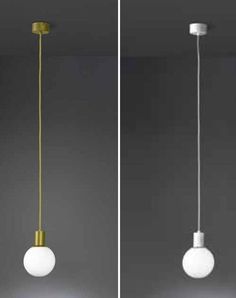 two white and gold lights hanging from the ceiling, one with a light bulb on it