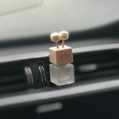 two small wooden objects sitting on top of a car dashboard