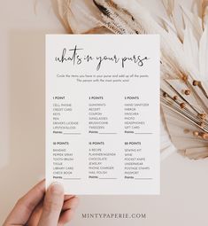 a person holding up a printable wedding seating chart with feathers around it and the words, what's in your purse?