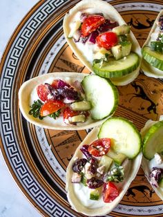 an overhead view of some tacos with toppings on a plate in the middle