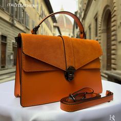 This bag has been made of the best genuine leather by local master crafters of Florence in Italy, designed for women who only accept premium Italian quality and luxury leather bags and modern Italian fashion. . Sizes: Width: 29cm/10.6 inch Height: 19cm/7.4 inch Depth: 7 cm/3.9 inch . The story of this bag :  In the heart of Florence, Italy, where the legacy of art and craftsmanship intertwines with the modern world, a master artisan named Sofia was crafting a piece of pure elegance - a Luxury Le Workwear Flap Bag With Textured Leather, Luxury Formal Vegetable Tanned Leather Shoulder Bag, Luxury Vegetable Tanned Leather Satchel, Leather Flap Bag With Smooth Grain For Daily Use, Modern Leather Flap Bag With Smooth Grain, Daily Use Leather Flap Bag With Smooth Grain, Luxury Cognac Flap Bag For Daily Use, Modern Orange Leather Satchel, Chic Orange Leather Satchel