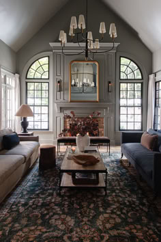 a living room with two couches and a coffee table in front of a fireplace