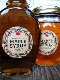 two jars of maple syrup sitting on a table next to each other with labels for maple syrup in them