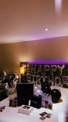 a birthday party with balloons and pictures on the table