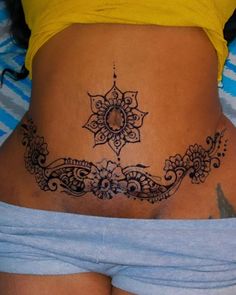 a woman's stomach with an intricate design on the side and bottom part of her belly