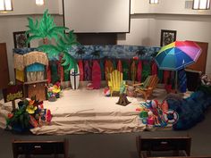 a stage set up with chairs, umbrellas and other decorations on the stage for children to play in