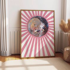 a pink and white wall with a disco ball in the center, on top of a wooden floor