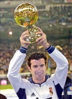 a man holding up a golden trophy in front of a crowd at a sporting event