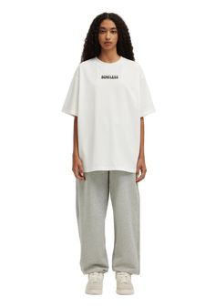 a woman wearing grey sweatpants and a white t - shirt with the words,