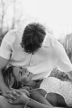 black and white photo of two people laying on the ground with one woman touching her face