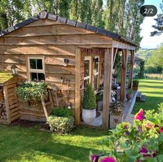 a small wooden shed sitting on top of a lush green field