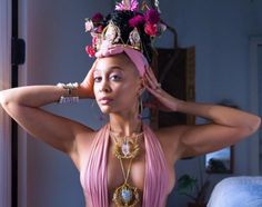 a woman in a pink dress with a crown on her head and jewelry around her neck