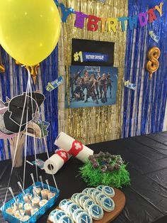 a table topped with lots of desserts and balloons