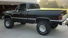 a black truck parked in front of a garage