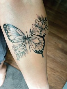 a woman's leg with a butterfly tattoo on it