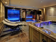 an indoor hot tub with blue lights in the background and two lounge chairs next to it