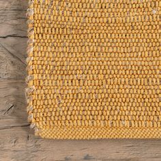 a close up view of an area rug on a wooden floor with wood planks in the background