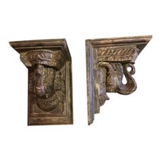 pair of antique cast iron shelf brackets with head and feather decoration on each end,