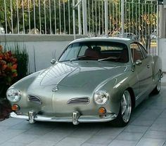 an old silver car parked in front of a building