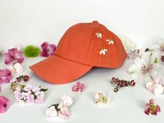 Burnt orange, adult-size, distressed hat, with adjustable strap on back.Daisy design has been hand embroidered on the cap for a unique touch!N O T E SIf the hat needs to be washed, hand wash (delicately) in cold water to avoid damage to the hand-embroidery.Embroidery floss catches different types of light in different ways. My display pictures are taken with lots of natural light. Your finished embroidered hat may appear different if placed in a dark area or under fluorescent lighting. All desig Daisy Hat, Fluorescent Lighting, Display Pictures, Distressed Hat, Daisy Design, Embroidered Hat, Sewing Embroidery Designs, Embroidered Hats, Embroidery Hoop Art