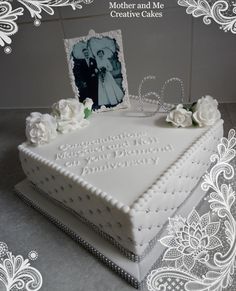 a wedding cake decorated with white flowers and an old photo