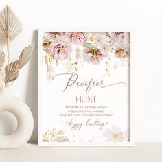 a white card with pink flowers and gold foil lettering on it next to a donut