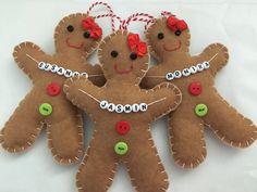 three gingerbread men ornament hanging on a white background with red and green buttons