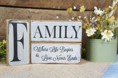 two wooden blocks that say family, where life begins and love never ends with flowers in the background