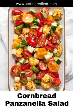 a white plate topped with tomatoes, cucumbers and cauliflower