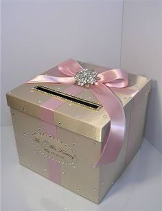 a pink and gold box with a bow on it